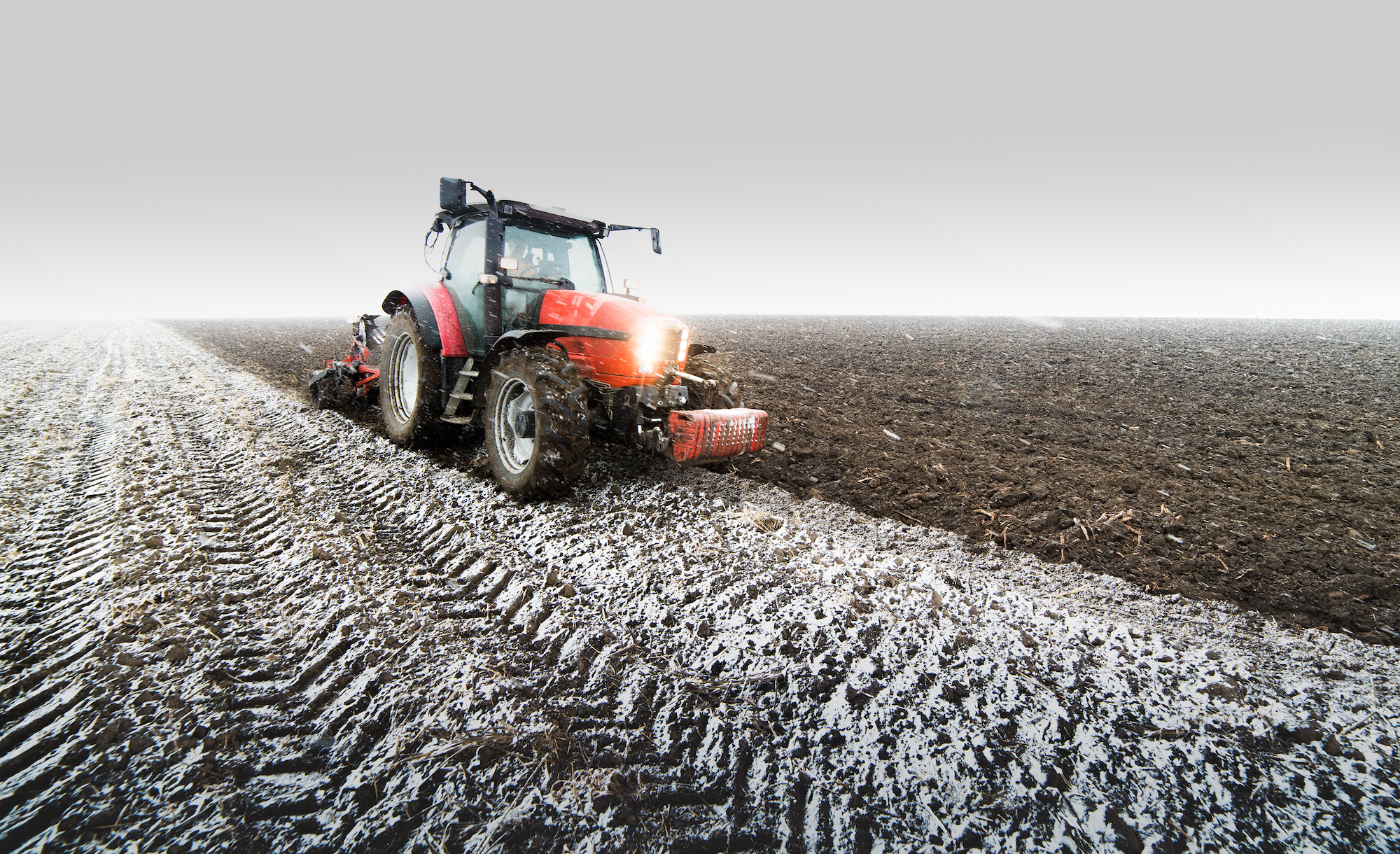 Tractor plowing a field in winter landowner essential winter prep