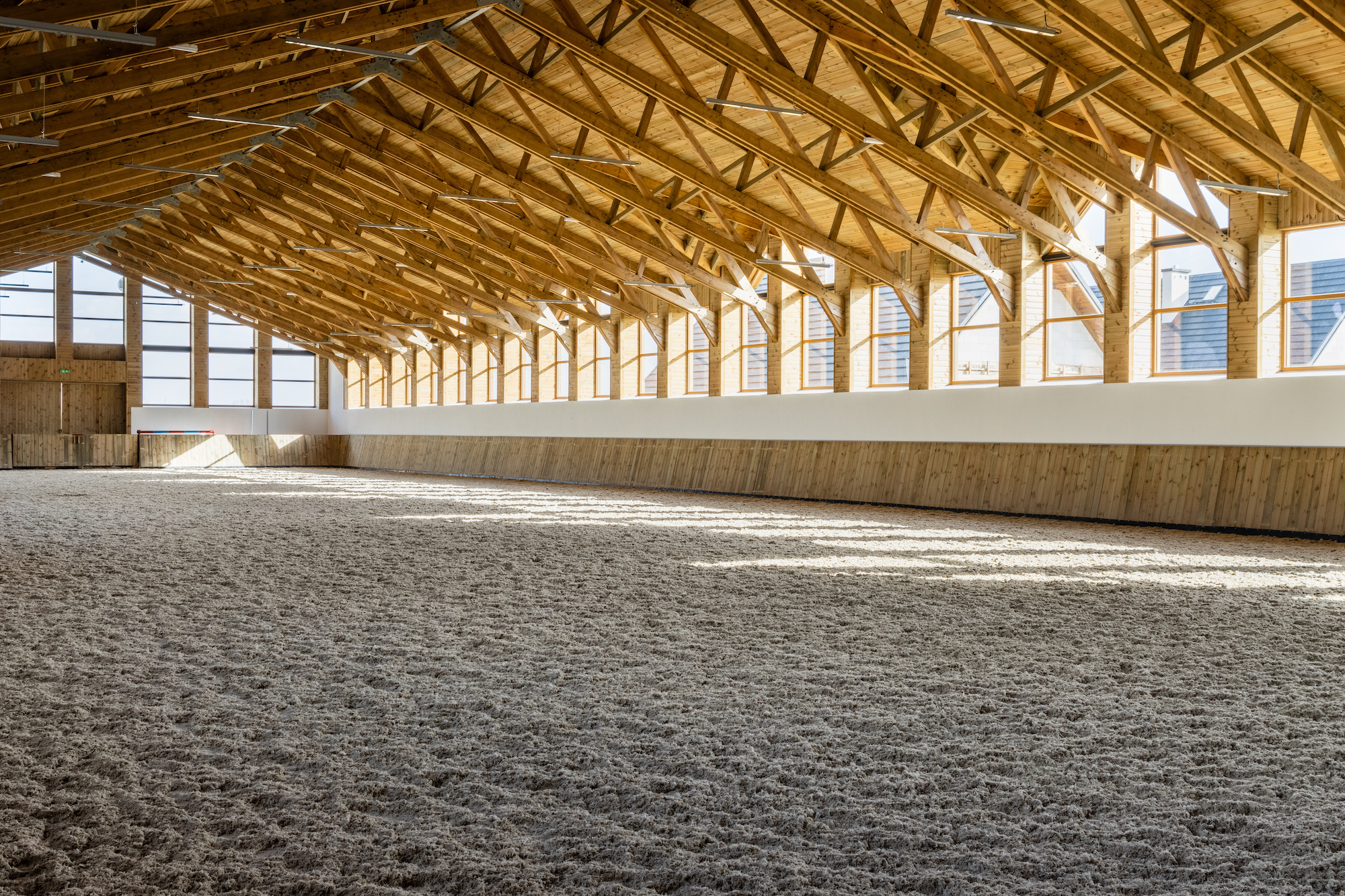 Empty spacious indoor arena interior view. Sunlight through windows.