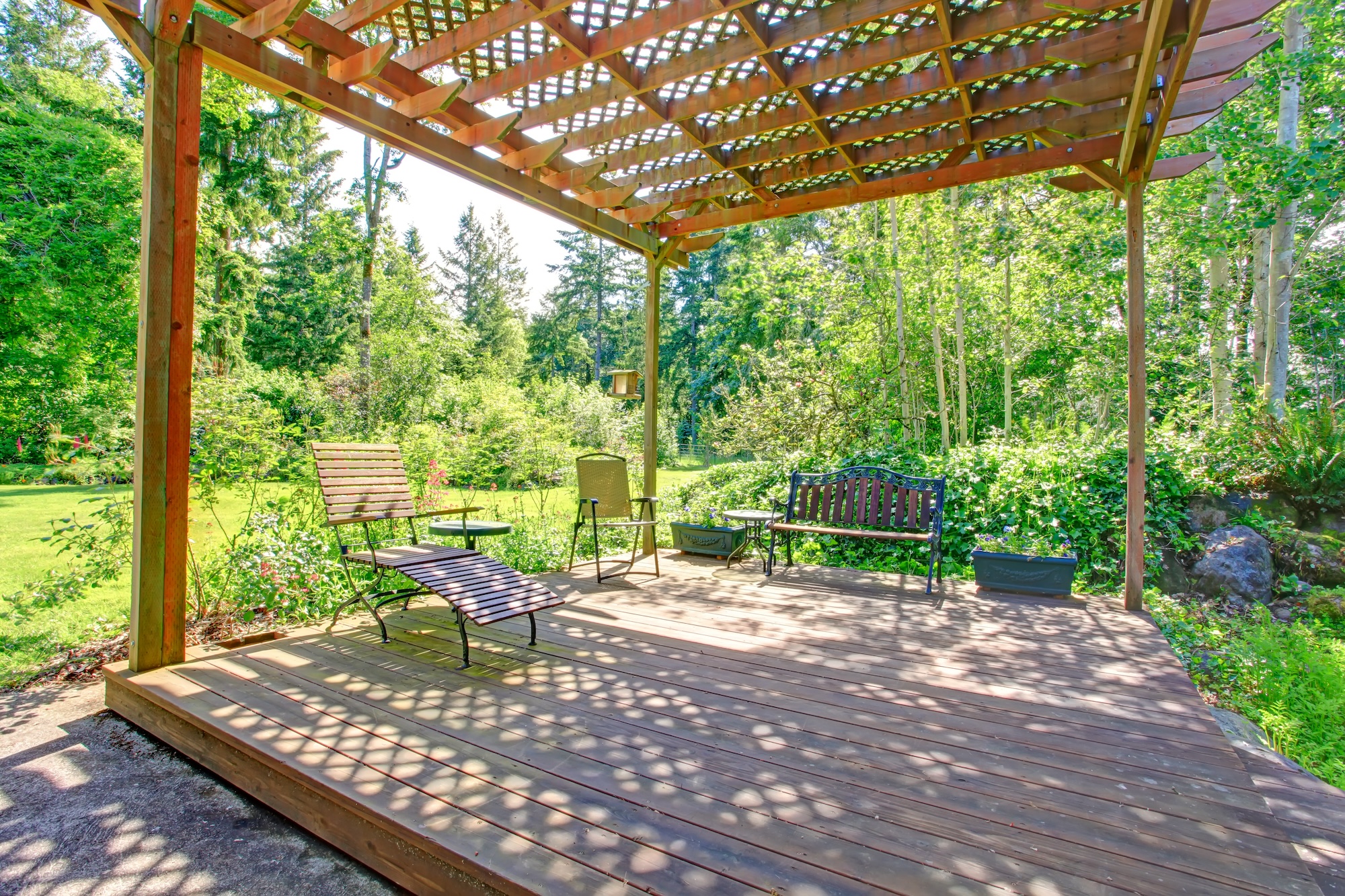 Open farm house pergola with rustic bench, chair and flower pots