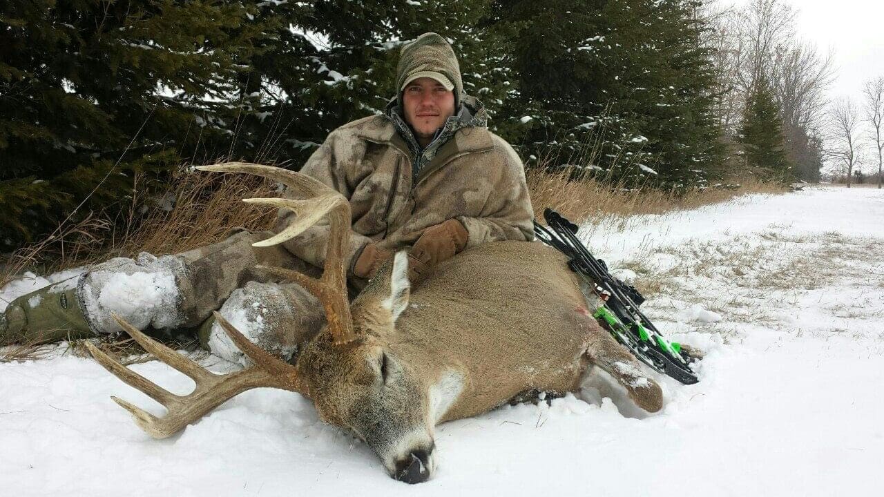agent jake hyland with a trophy buck in the snow
