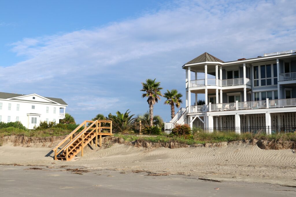 Wooden stair to the beach from oceanfront houses for living and vacation rental in the morning sunlight. Atlantic ocean coast, South Carolina, USA.