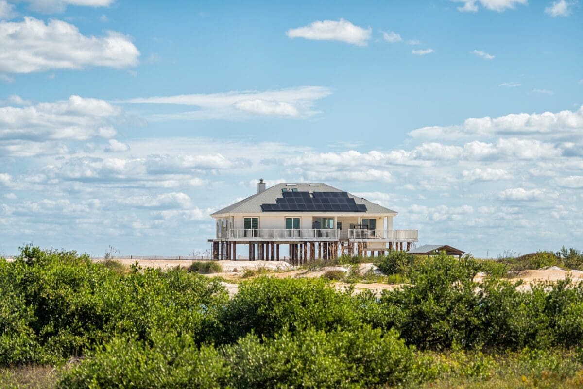 Stilted vacation house on stilts at oceanfront property of Atlantic ocean beach at Crescent Beach in the Palm Coast of Florida for hurricane protection and solar panels on sunny day