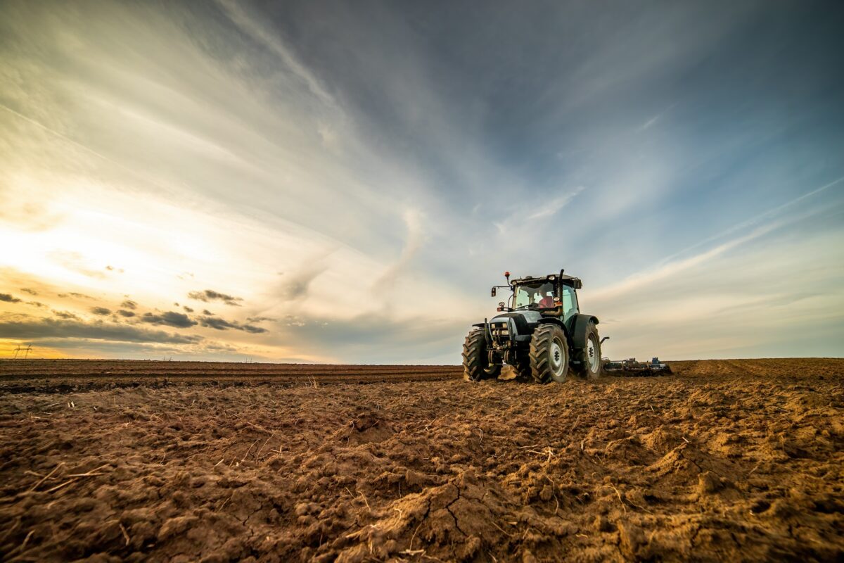 tractor equipment in the middle of a dirt field on a small farm