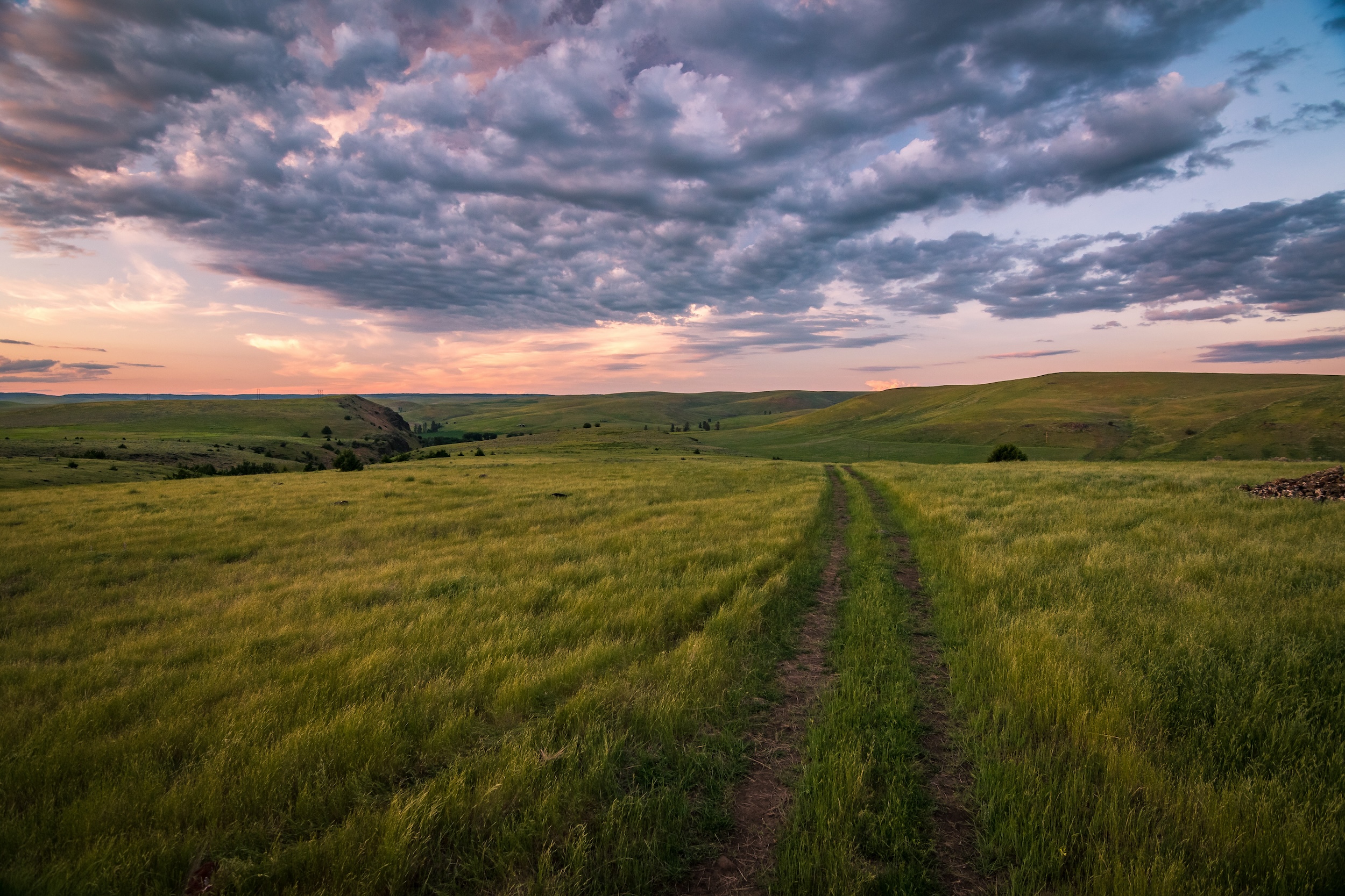 visual of the surface rights of a rolling plains rural real estate property with puffy clouds at sunset overhead