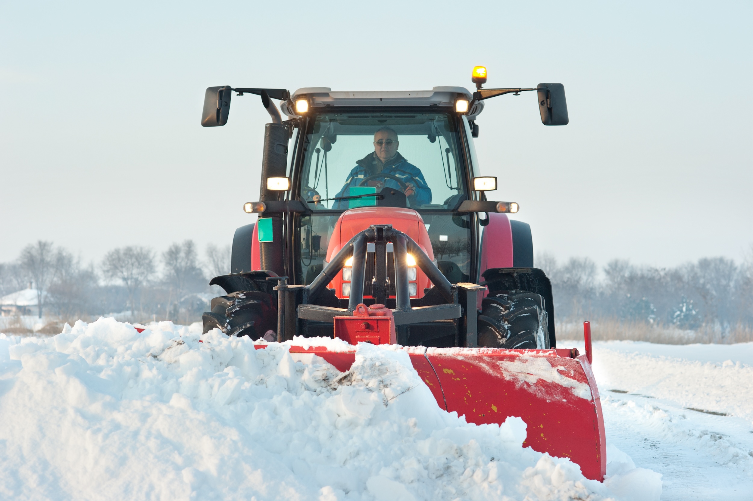 red tractor shoveling snow