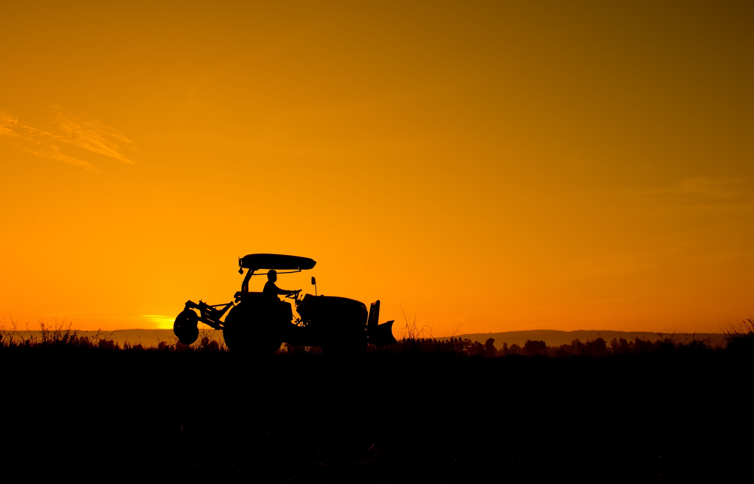 silhouette of a tractor at sunset