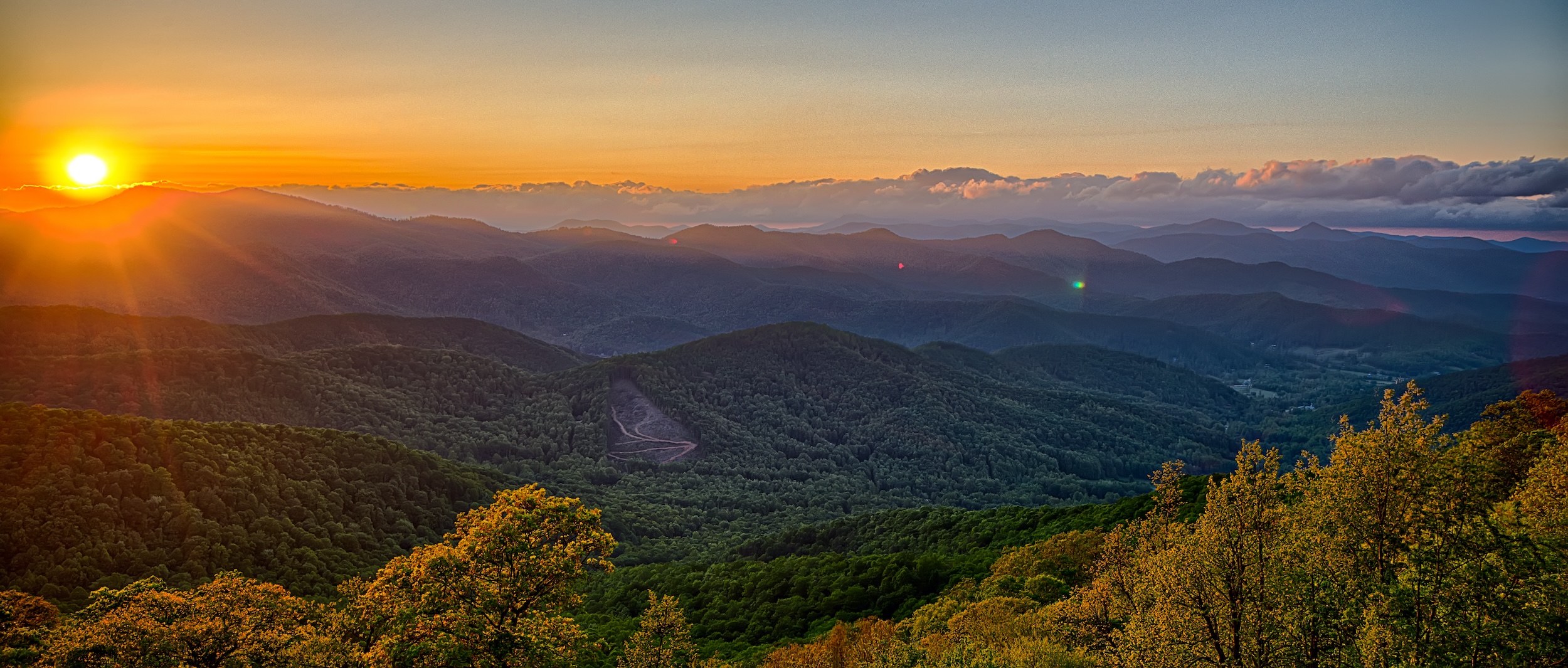 sun setting behind a mountain property in the southeast United States held by a land trust