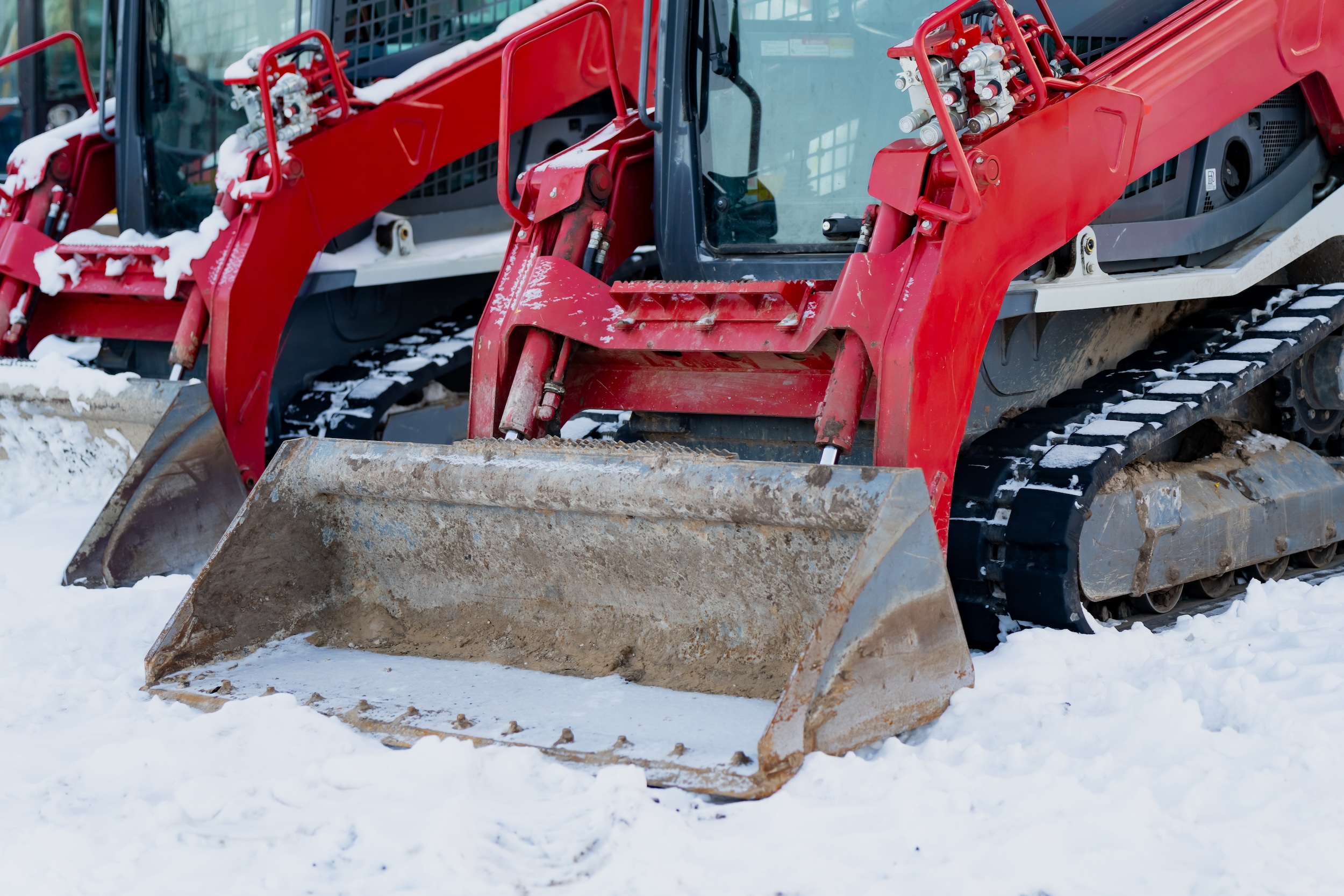 red skid steer being used for snow clearing and removal