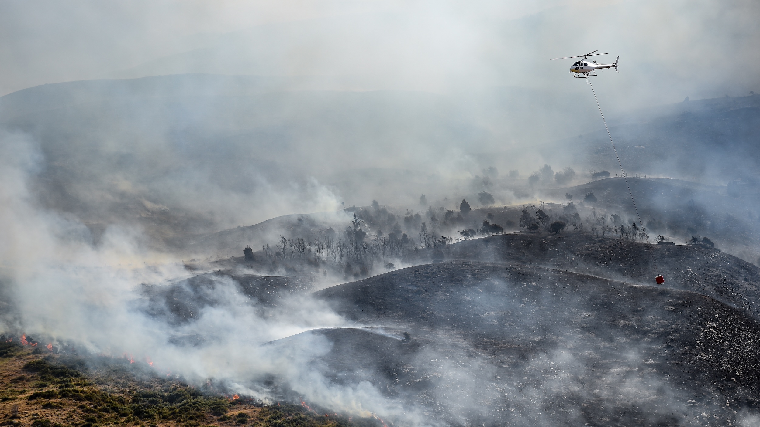 smoke rising up from a wildfire that has been mitigated and put out in a mountainous region