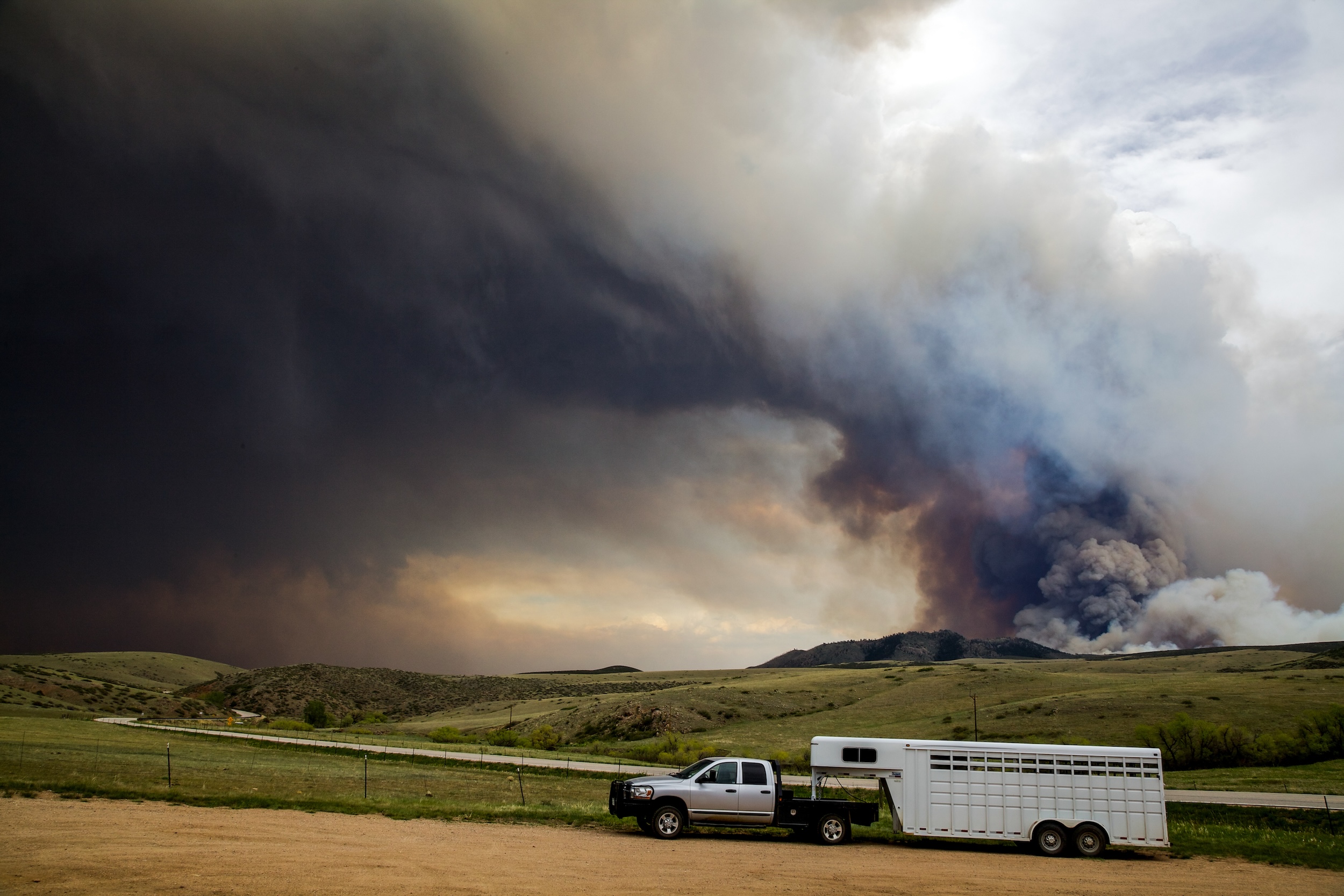 trailer hauling livestock away from a wildfire in the mountains