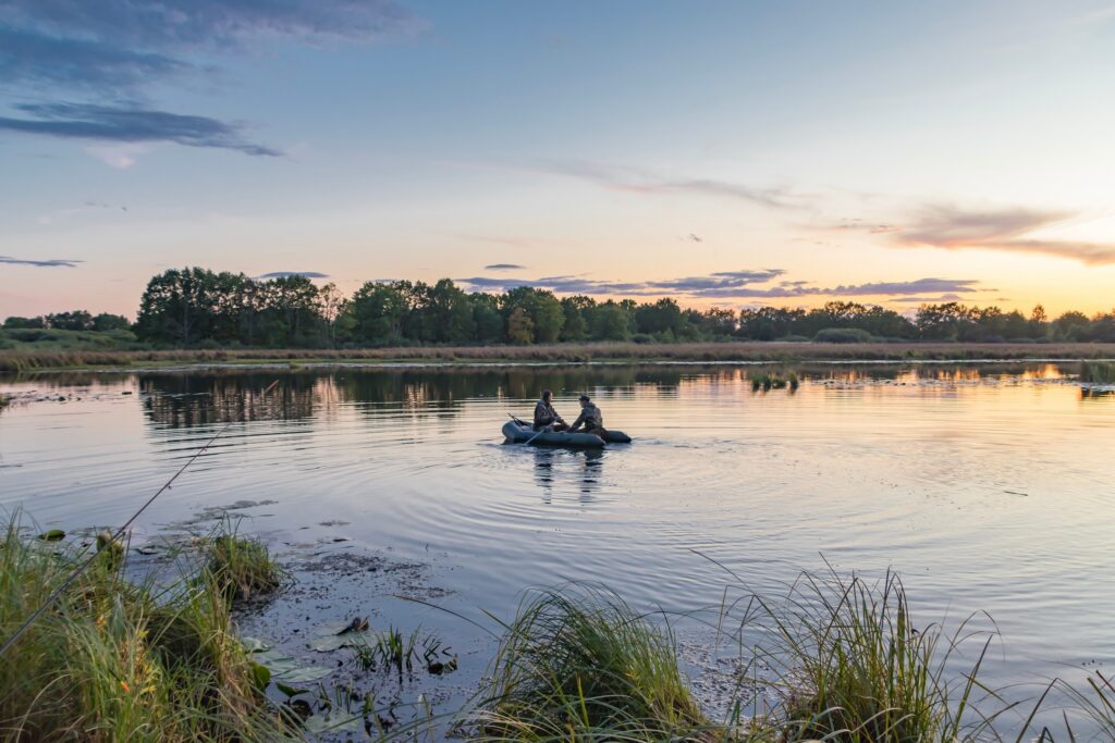 two people in a boat during dawn in preparation for duck hunting