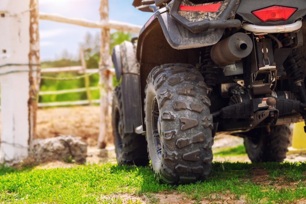 close up of an atv parked in front of the fence on a farm property