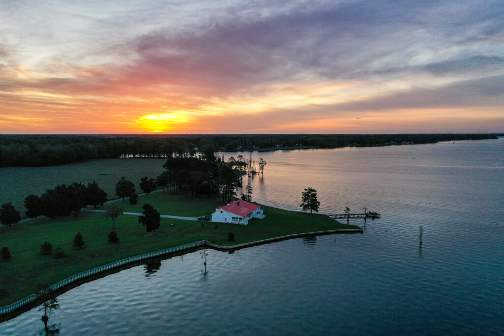 coastline home sitting by the water at sunset, represented by a good Hayden Outdoors real estate agent