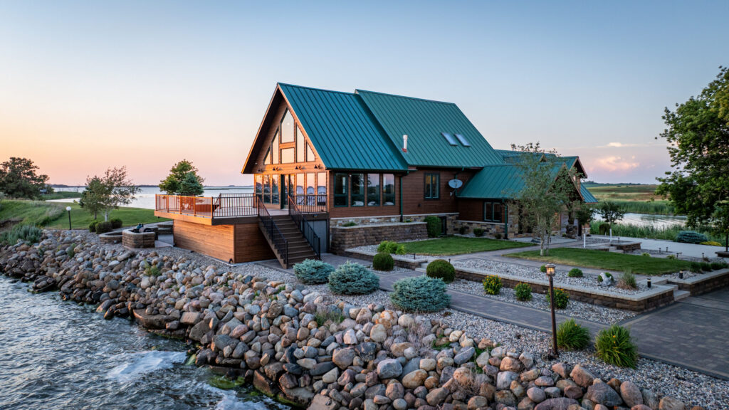 a frame style luxury cabin represented by a Hayden Outdoors real estate agent sitting on the shoreline during sunset