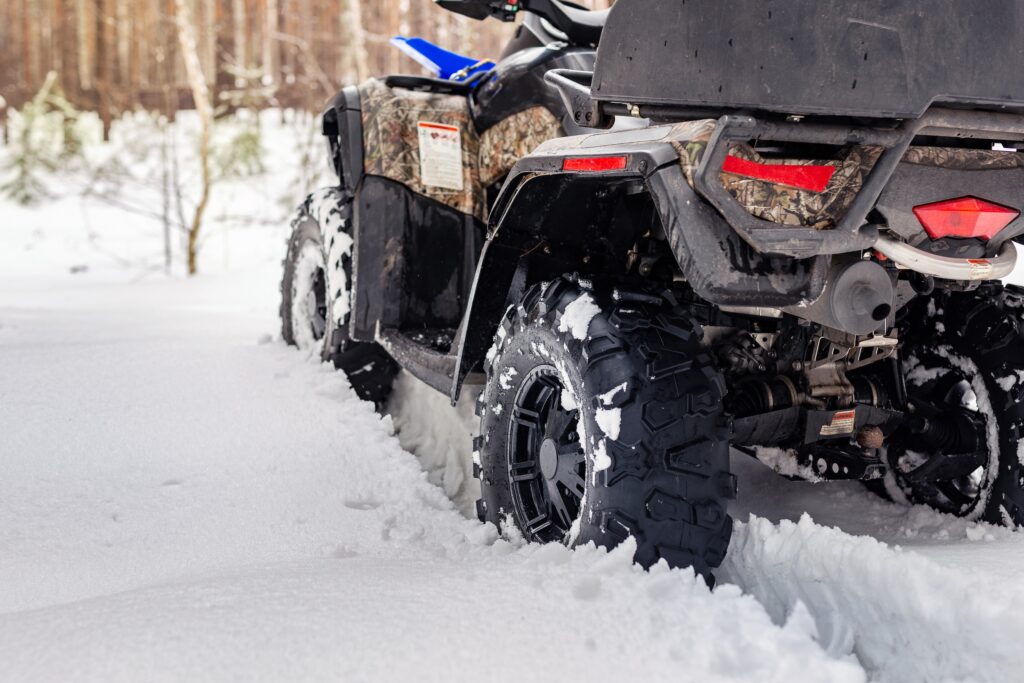 close up of the wheels on a four wheeler atv in the snow