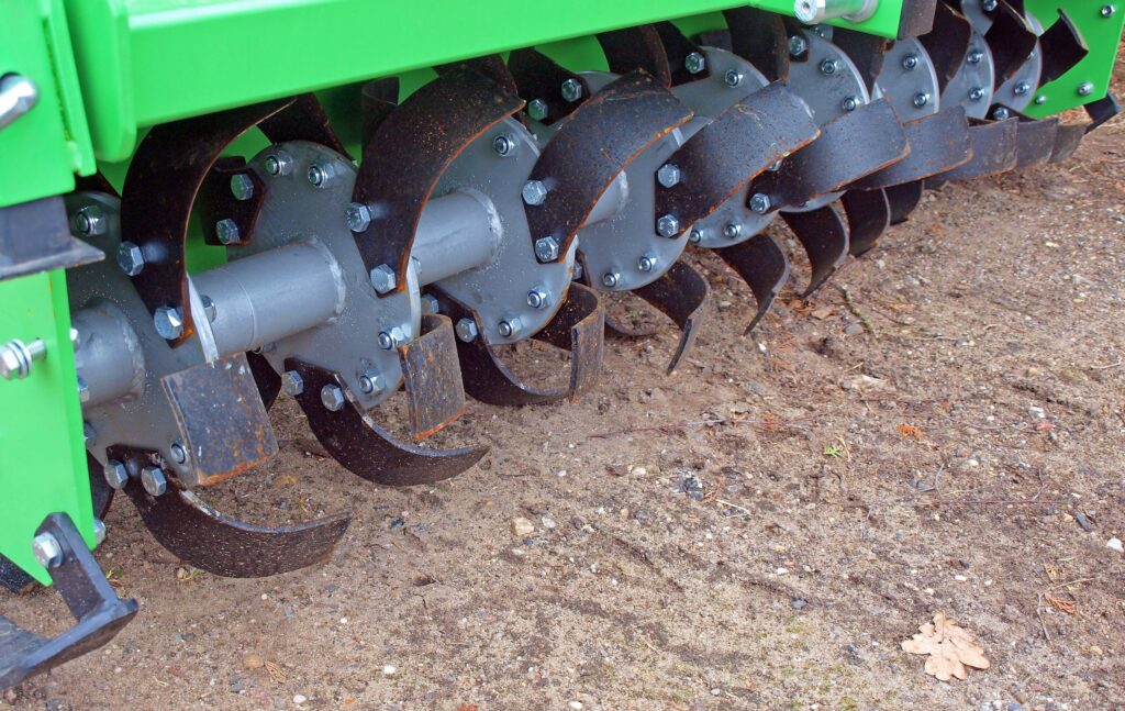 sharp curved blades of a rotary tiller vs the less deep blades of a disc harrow
