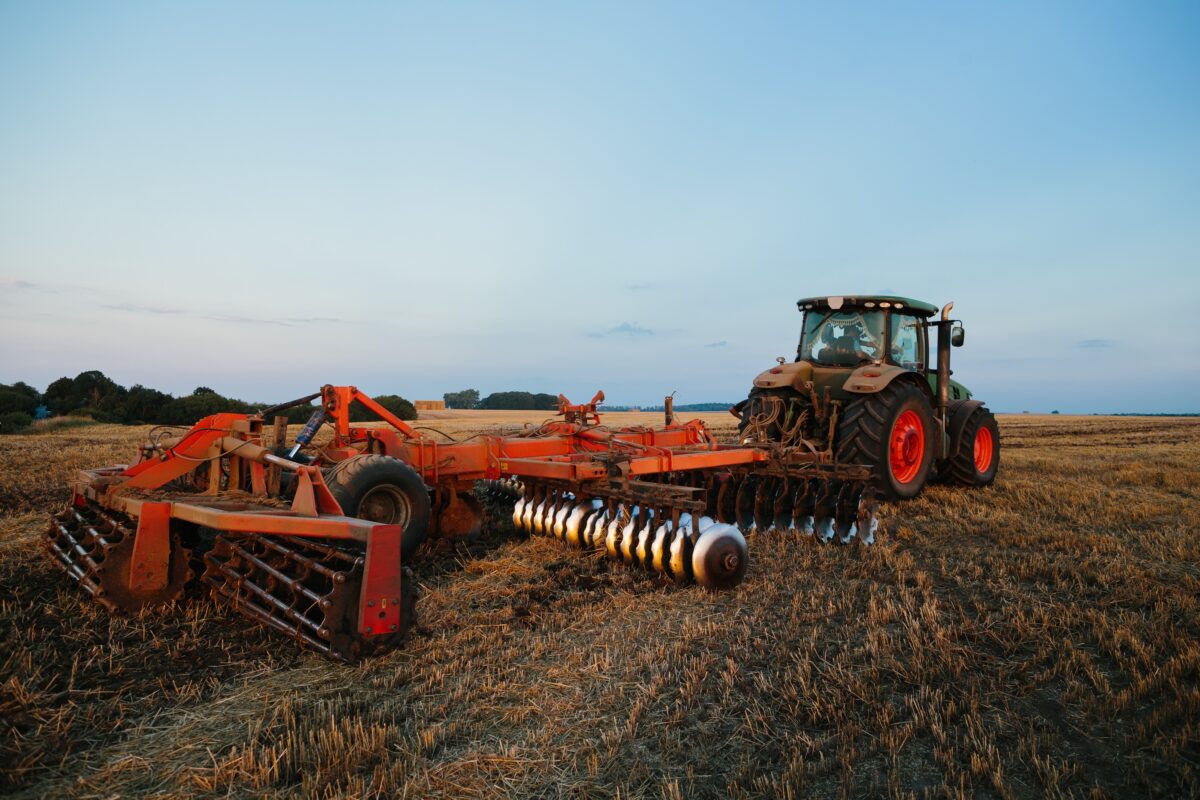 tractor hauling a disc harrow over a field