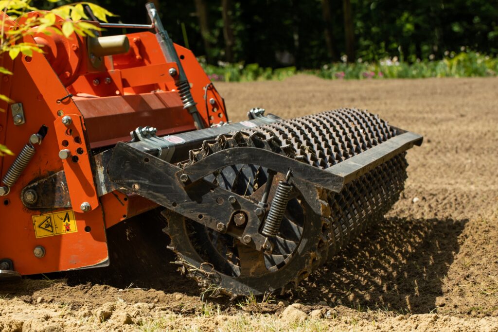 disc harrow attached to a tractor running across farmland