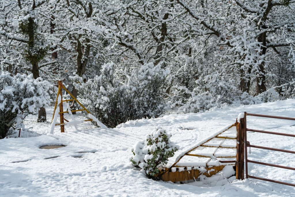 snow collecting on a cattle guard on a ranch in the winter